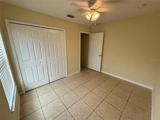 an empty room with fan and entrance