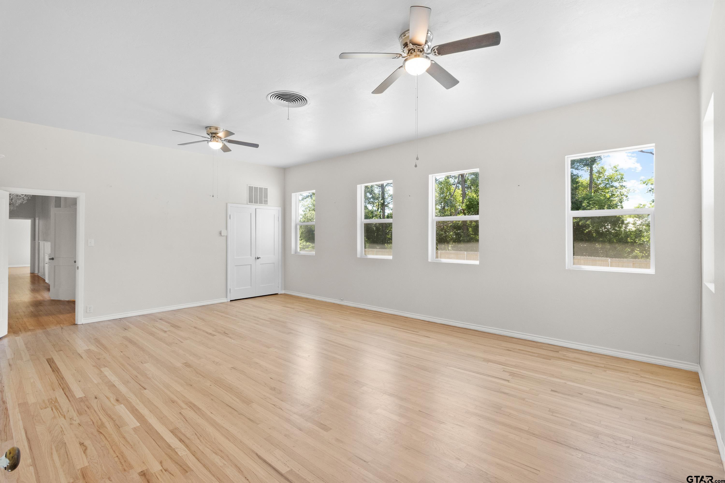 4456 Farm To Market Road 2767 Tyler, TX 75708 - Photo 13 of 46 a view of empty room with wooden floor and fan