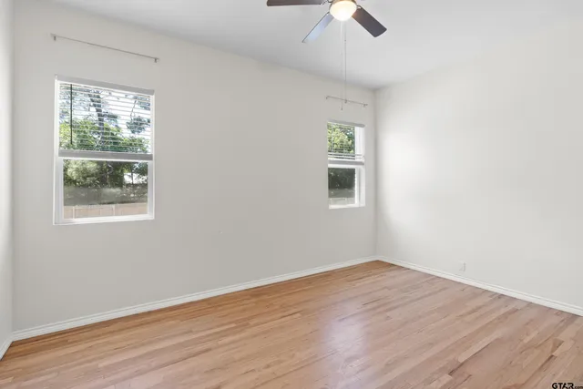 an empty room with a window and wooden floor