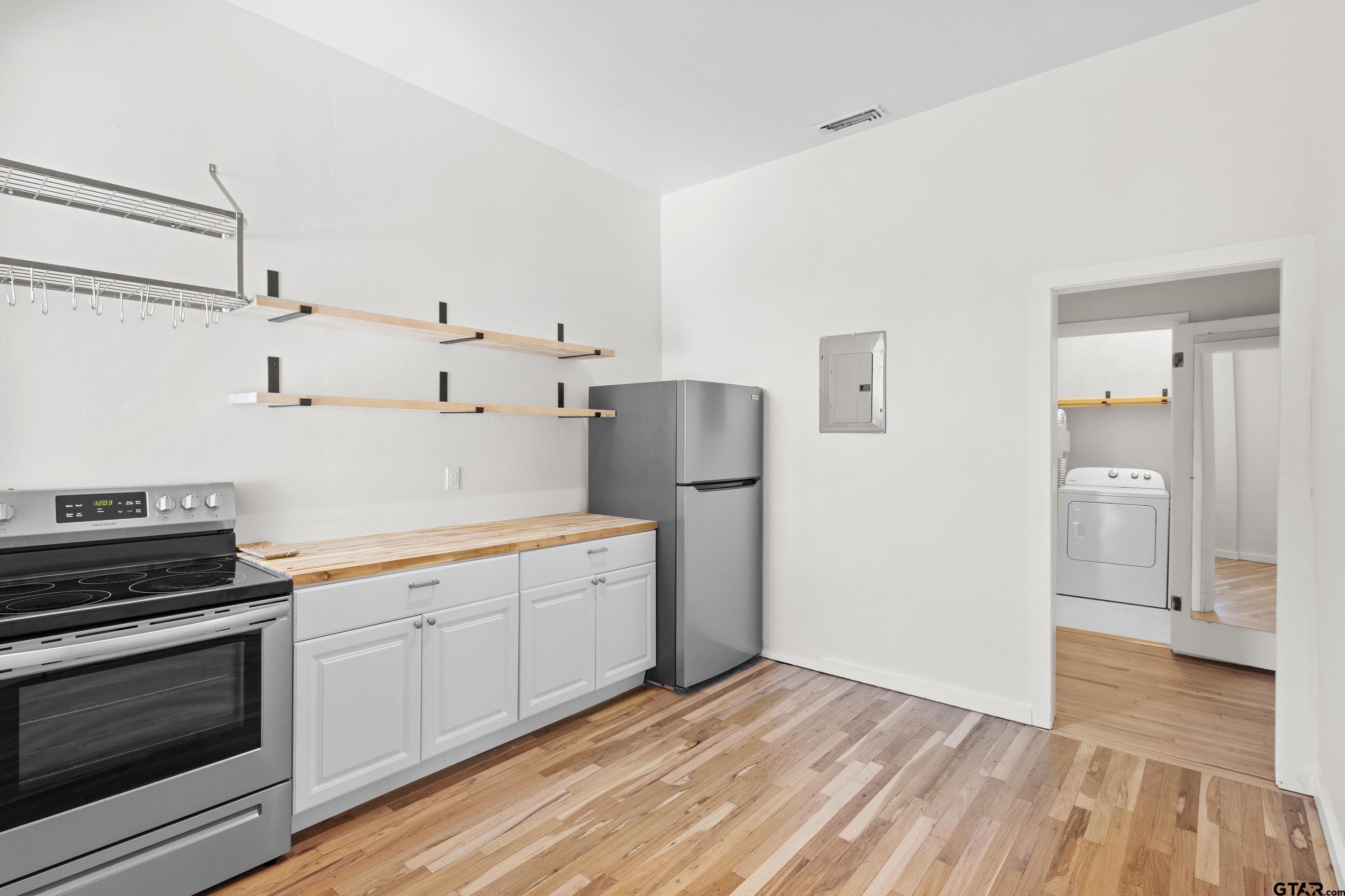 4456 Farm To Market Road 2767 Tyler, TX 75708 - Photo 20 of 46 a view of a kitchen with refrigerator stove and wooden floor