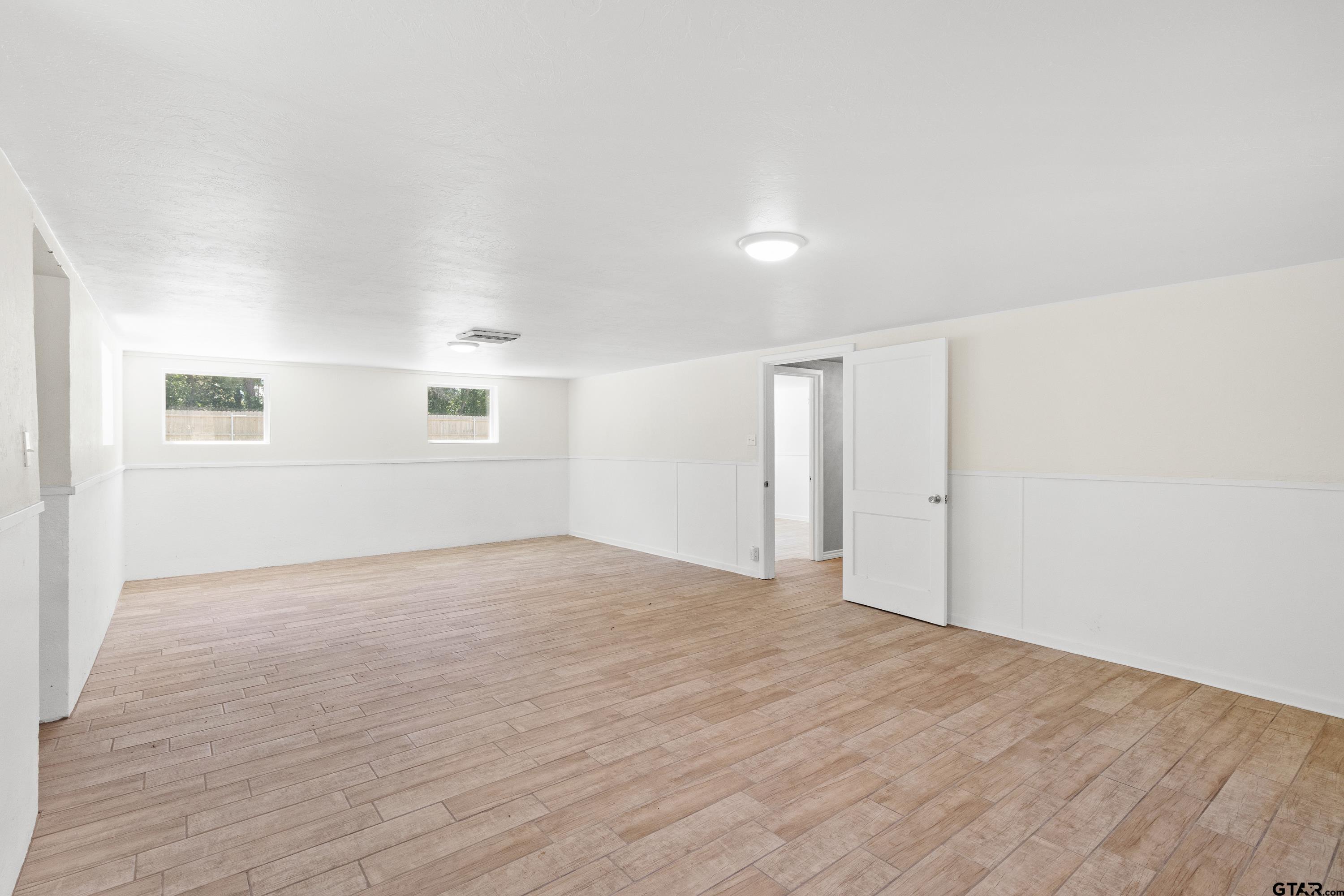 4456 Farm To Market Road 2767 Tyler, TX 75708 - Photo 27 of 46 a view of an empty room with wooden floor and a window