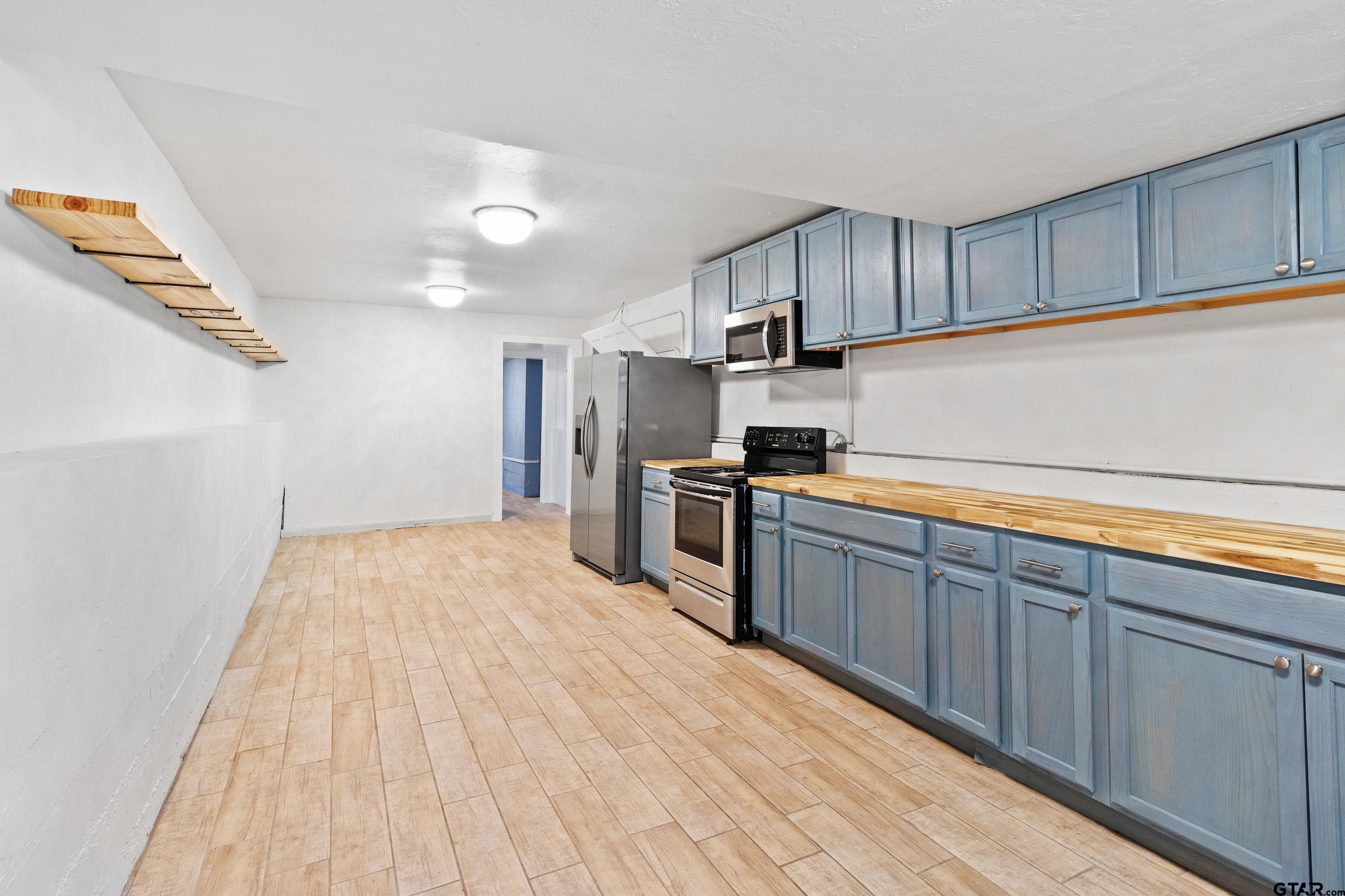 4456 Farm To Market Road 2767 Tyler, TX 75708 - Photo 37 of 46 a kitchen with stainless steel appliances granite countertop a refrigerator sink and cabinets
