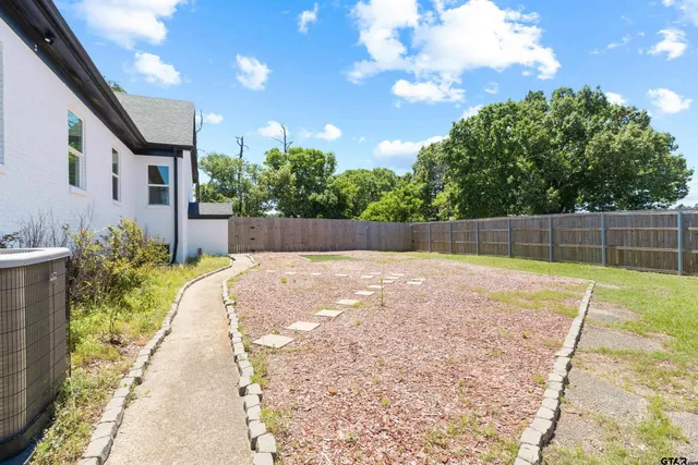 a view of backyard with potted plants and wooden fence