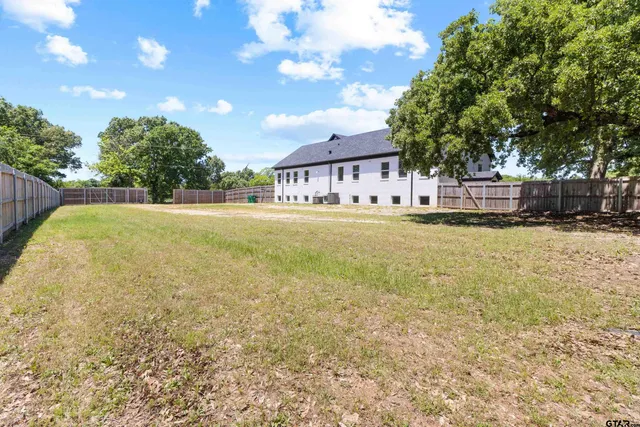 a view of a house with a yard and tree