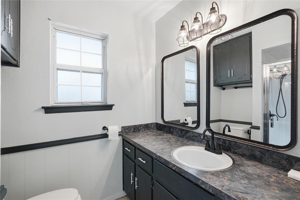 837 Springdale Road Bedford, TX 76021 - Photo 22 of 28 Vanity area featuring a dark countertop, an oval undermount sink, and a matte black single-handle faucet