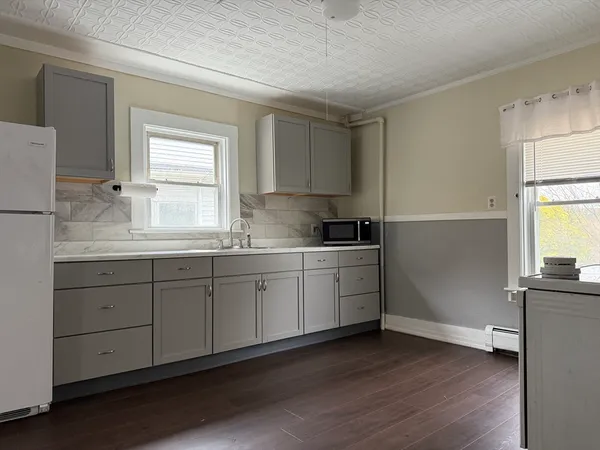 a kitchen with granite countertop white cabinets and white appliances