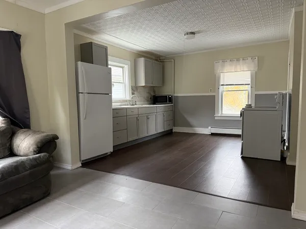 a kitchen with cabinets and wooden floor