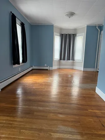 a view of room with window and wooden floor