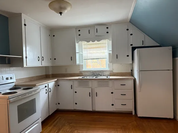 a kitchen with granite countertop white cabinets and white appliances