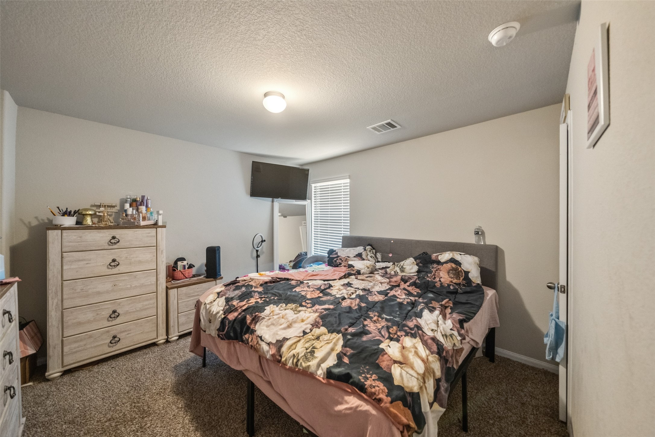 2302 Raider Drive Conroe, TX 77301 - Photo 3 of 25 a bed sitting in a bedroom next to a window with dresser