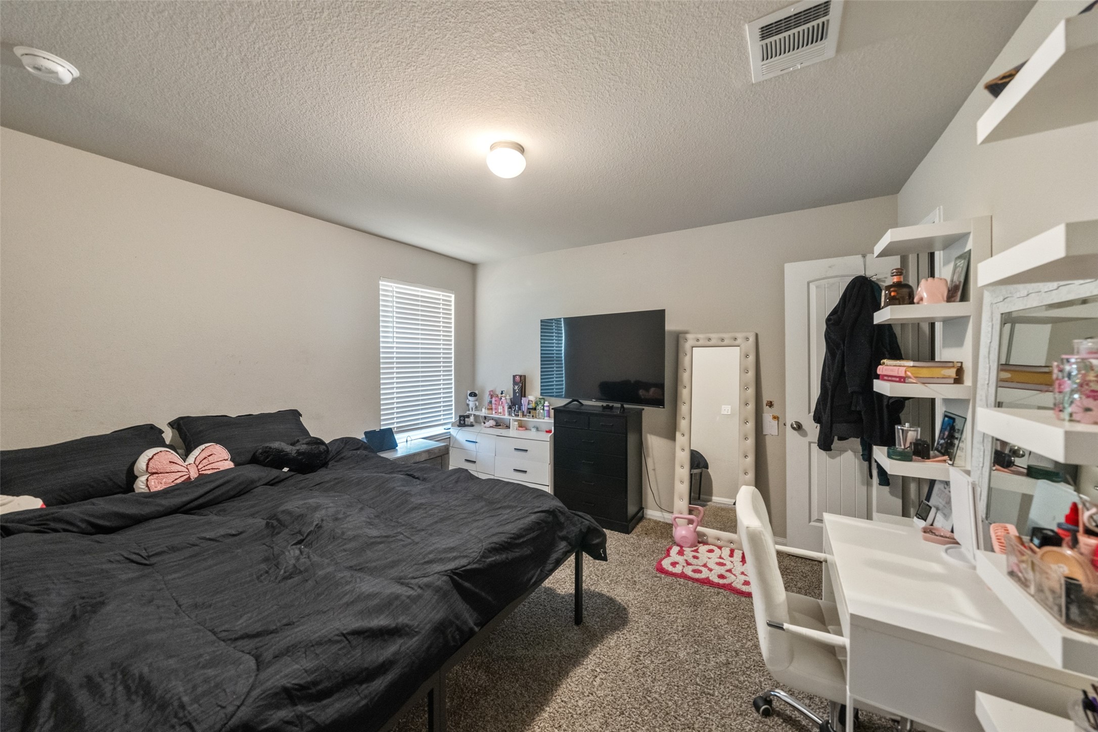 2302 Raider Drive Conroe, TX 77301 - Photo 4 of 25 a bedroom with a bed a flat screen tv and dresser