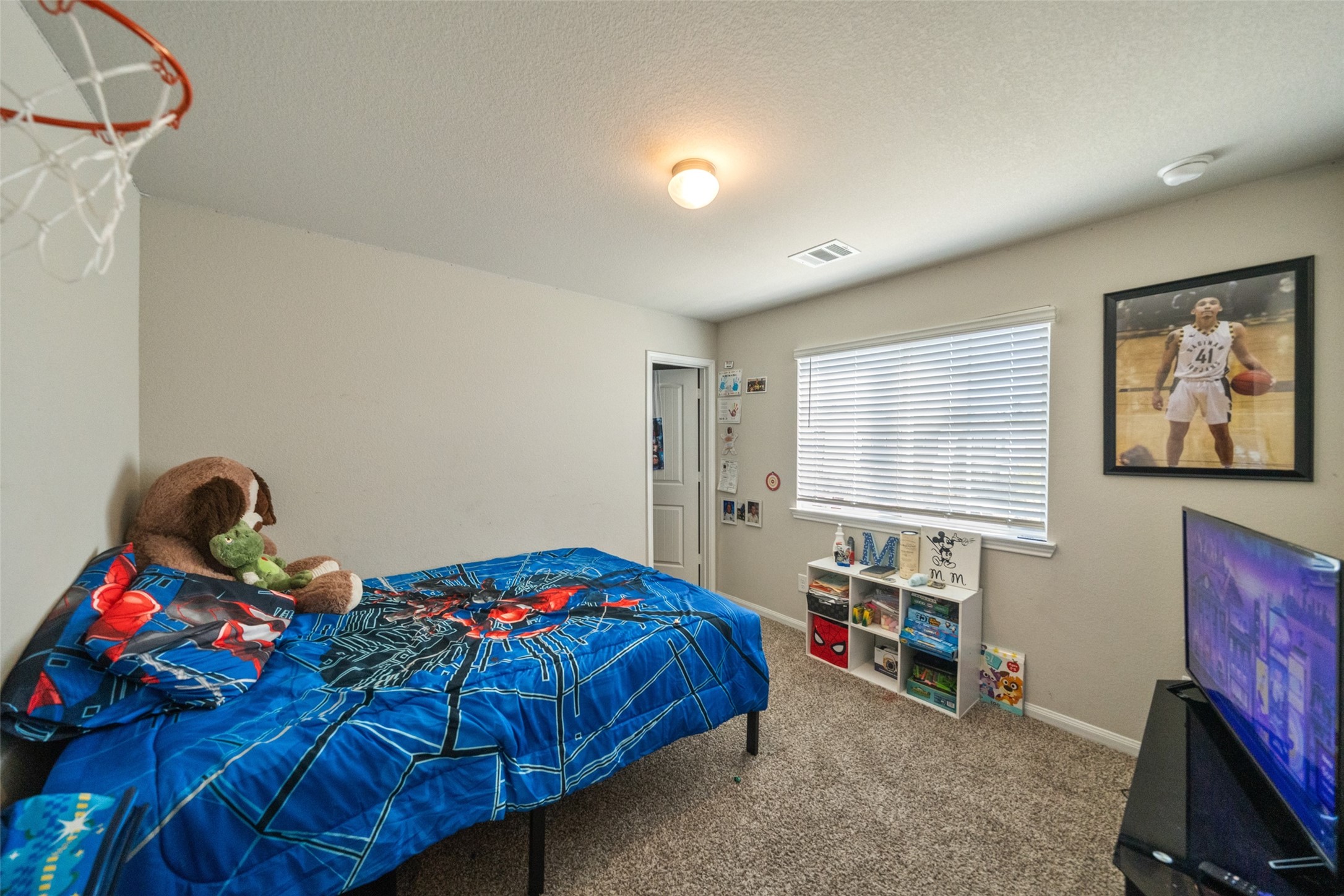 2302 Raider Drive Conroe, TX 77301 - Photo 7 of 25 a bedroom with a bed a dresser and a painting