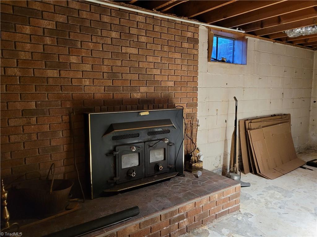 574 Hardin Camp Road Ennice, NC 28623 - Photo 44 of 50 Basement Fireplace with Woodstove