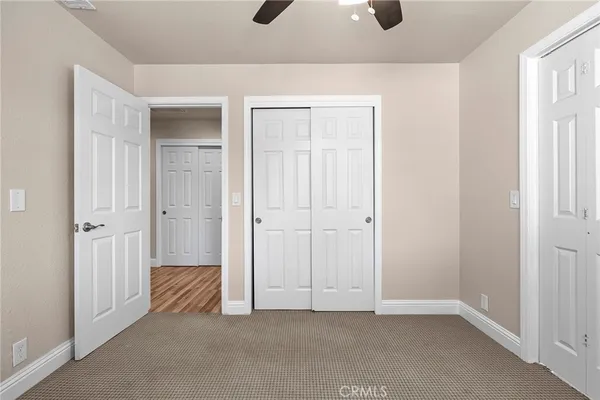 an empty room with a window and a fan