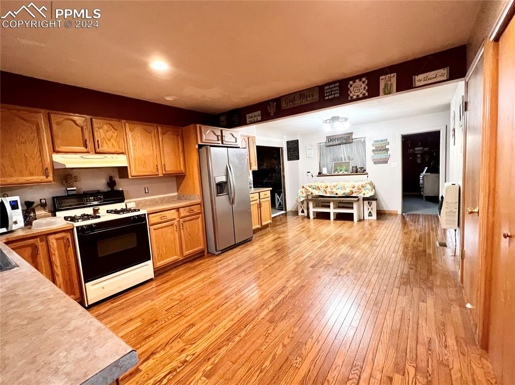 34650 Bellemont Road Yoder, CO 80864 - Photo 18 of 29 a kitchen with stainless steel appliances a stove a refrigerator and wooden floor