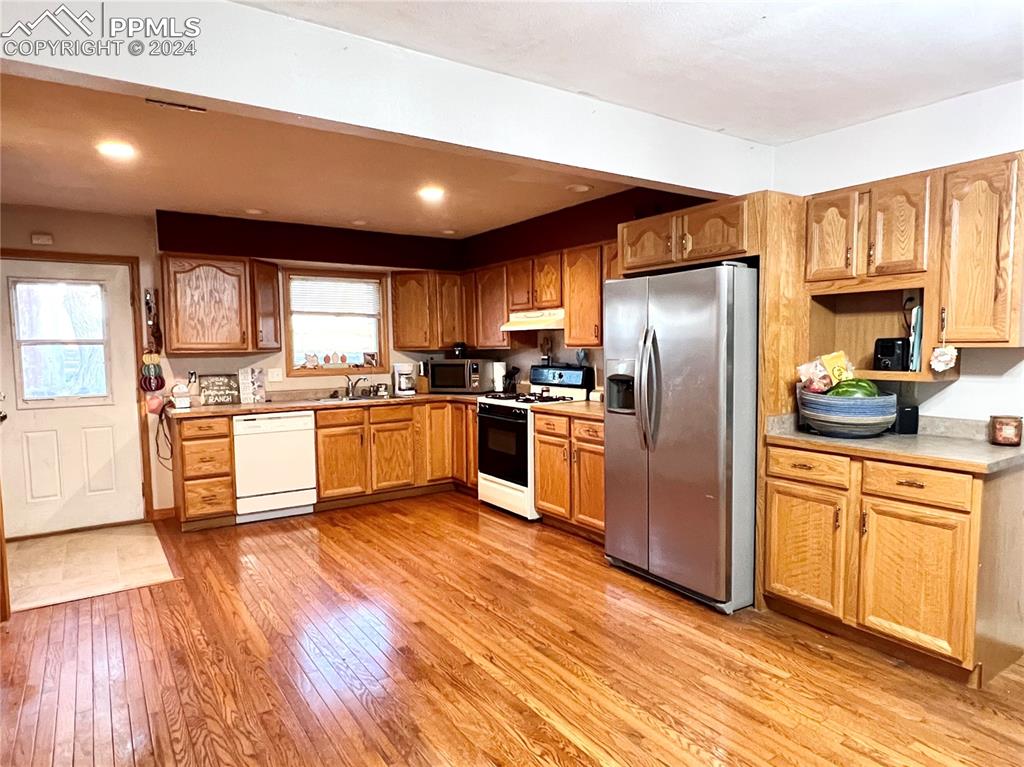 34650 Bellemont Road Yoder, CO 80864 - Photo 19 of 29 a kitchen with granite countertop stainless steel appliances a sink a window and cabinets