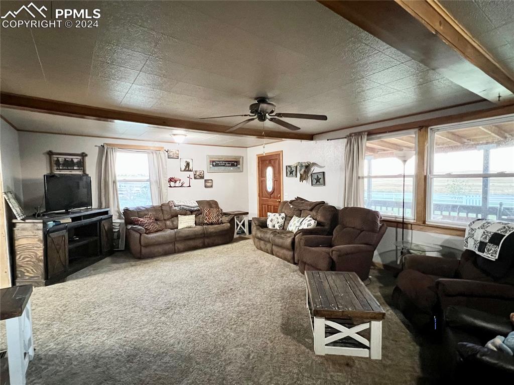 34650 Bellemont Road Yoder, CO 80864 - Photo 23 of 29 a living room with furniture floor to ceiling window and a flat screen tv