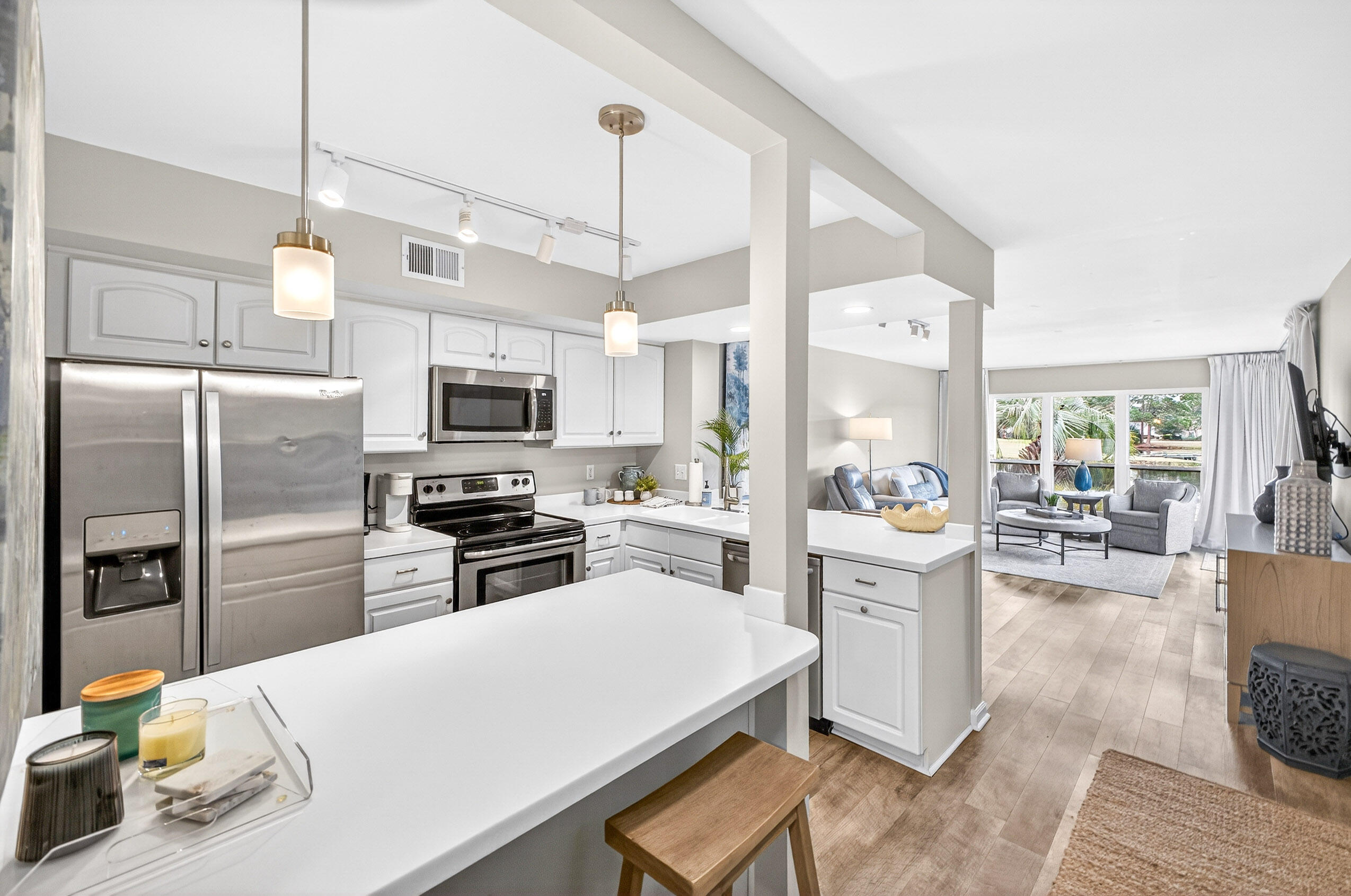 900 Harbour Point Lane, Unit 900 Miramar Beach, FL 32550 - Photo 6 of 64 a kitchen with a refrigerator a stove top oven a sink dishwasher and white cabinets with wooden floor