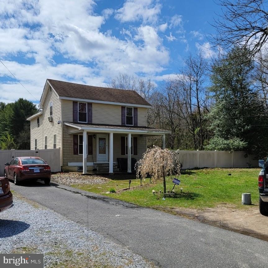 a front view of a house with a garden and trees