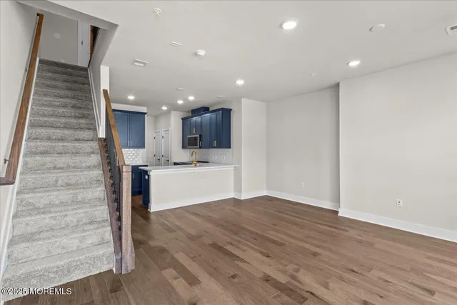 a view of kitchen with kitchen island microwave and wooden floor