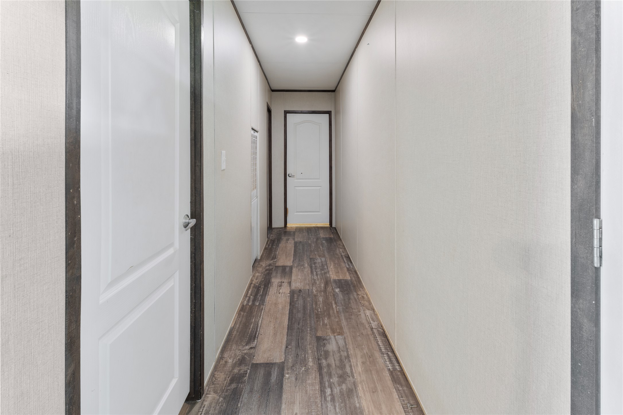 109 Hibiscus Cove Elgin, TX 78621 - Photo 11 of 15 An inviting hallway with plank flooring leads to a well-lit entrance.