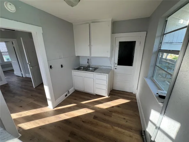 a kitchen with a sink and wooden floor