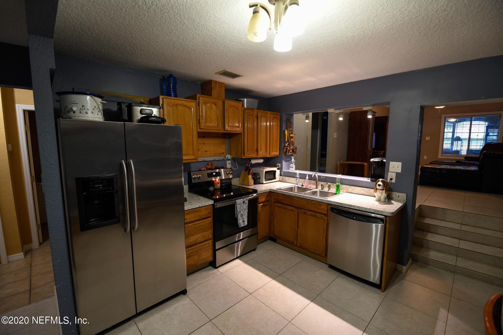 259 Brickyard Road, Unit C Middleburg, FL 32068 - Photo 6 of 17 a kitchen with stainless steel appliances granite countertop a sink and a refrigerator