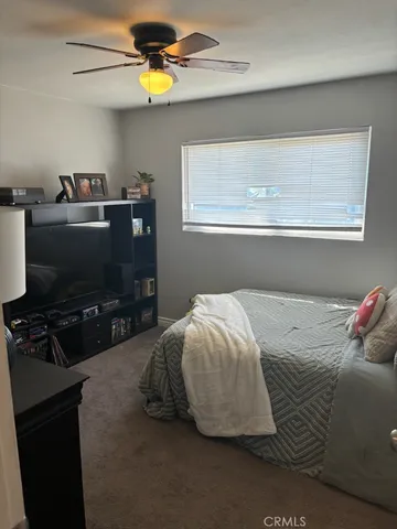 a bedroom with a bed and a flat tv screen on the dresser