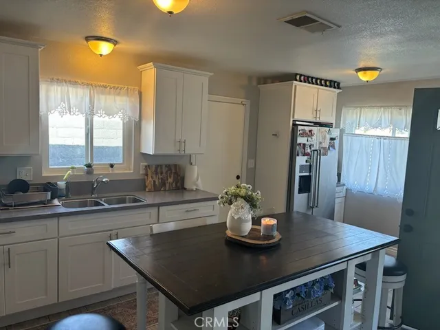 a kitchen with stainless steel appliances granite countertop a sink a stove and refrigerator