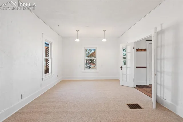 an empty room with a cabinet and mirrors