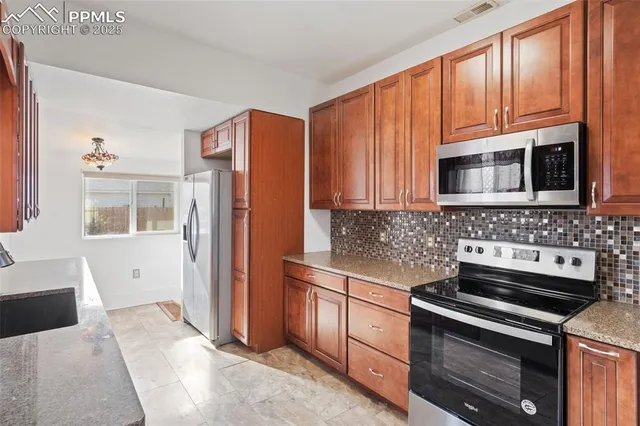 a kitchen with stainless steel appliances granite countertop a stove microwave and refrigerator