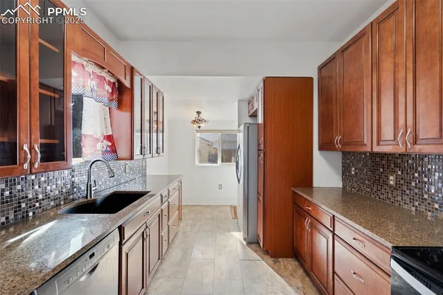 a kitchen with granite countertop a sink and a refrigerator