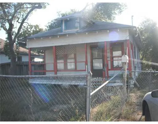 a view of a small house with wooden fence