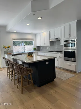 a kitchen with a stove a sink a dining table and chairs