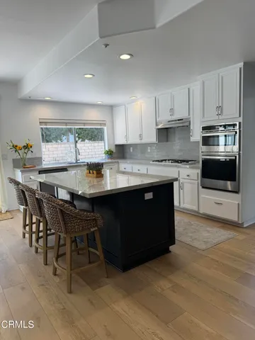 a kitchen with a stove a sink a dining table and chairs