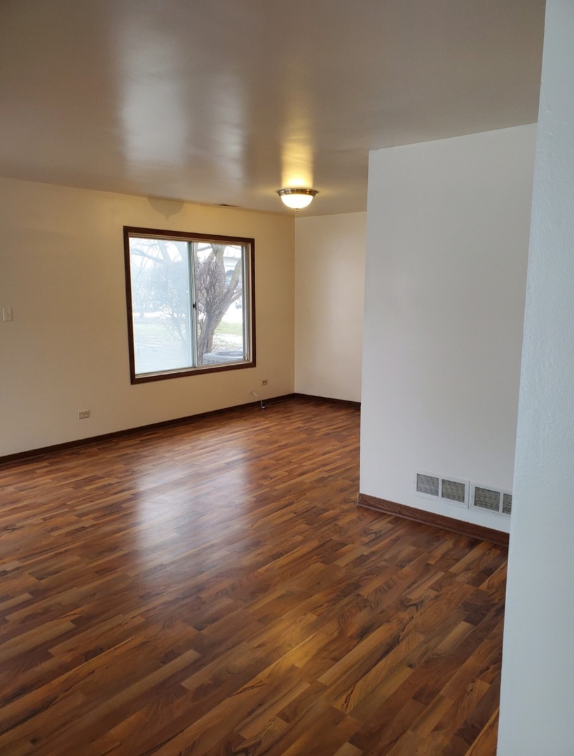 54 Churn Road Matteson, IL 60443 - Photo 4 of 19 a view of an empty room with wooden floor and a window