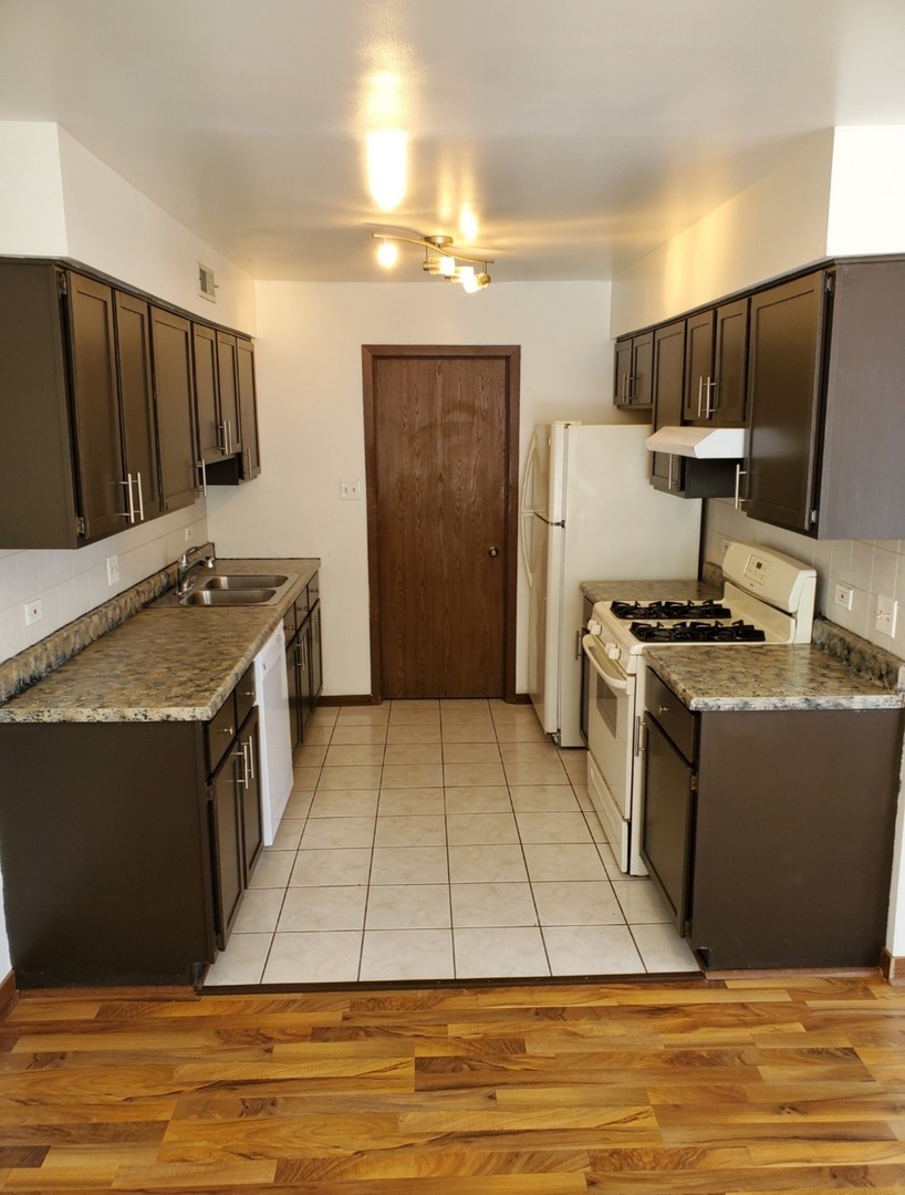 54 Churn Road Matteson, IL 60443 - Photo 6 of 19 a kitchen with granite countertop a stove and a refrigerator