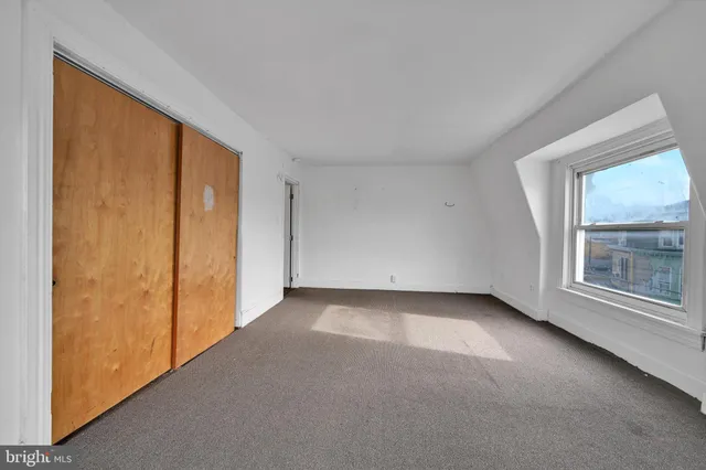 a view of a livingroom with an empty space and a window