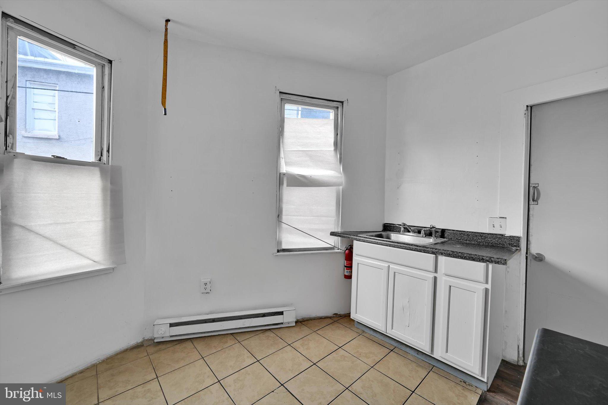 525 Bingaman Street Reading, PA 19602 - Photo 25 of 27 a kitchen with granite countertop a stove a sink and white cabinets
