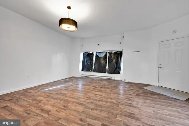 a view of an empty room with a window and a fireplace