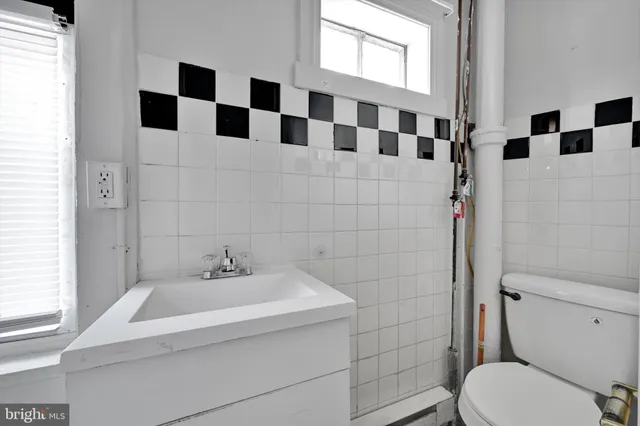 a bathroom with a sink a toilet and shower curtain