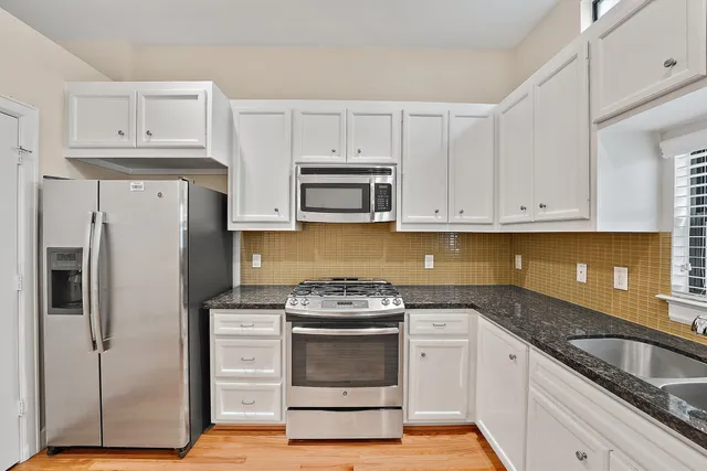 a kitchen with granite countertop wooden floors and stainless steel appliances