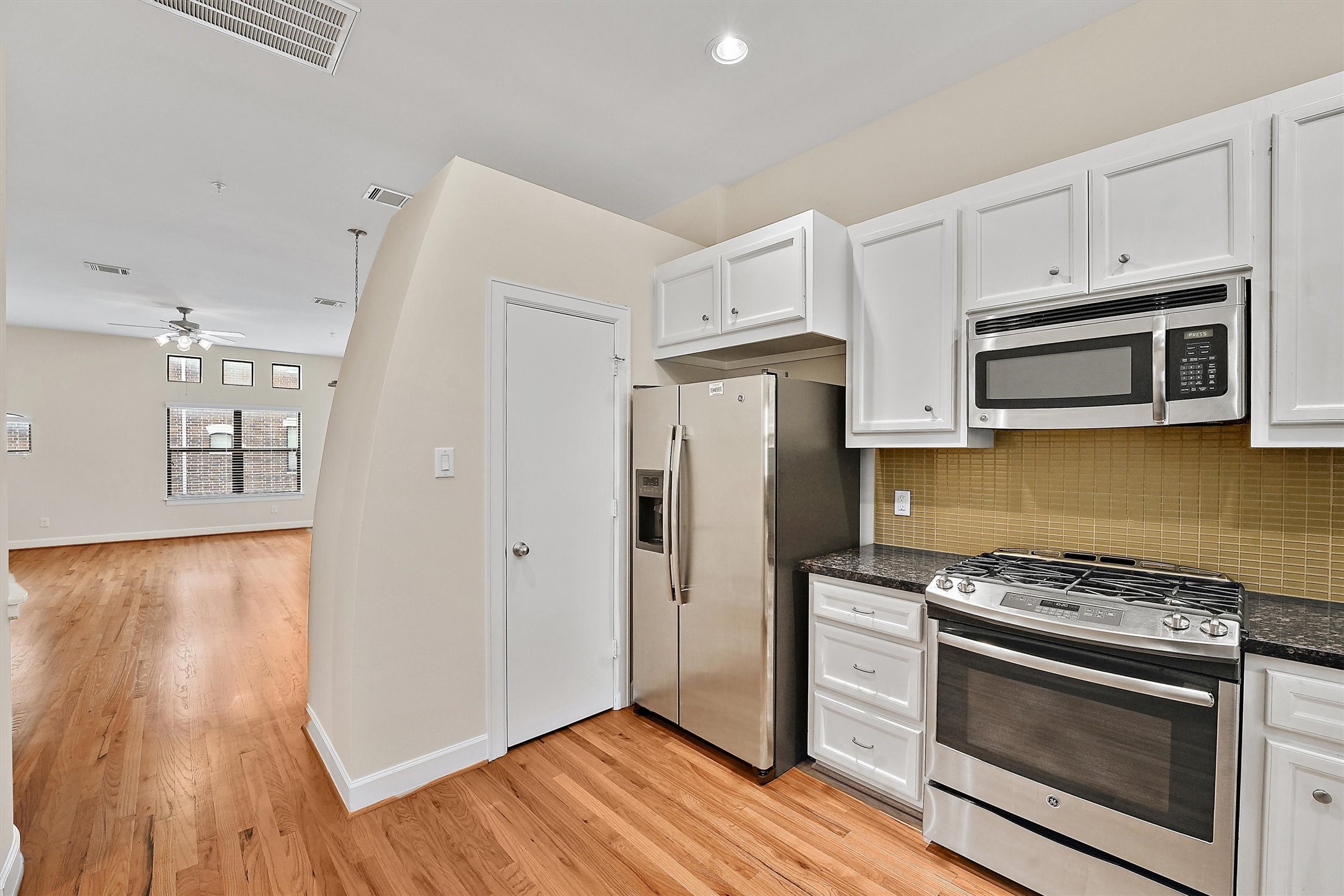 2710 Hullsmith Drive, Unit 903 Houston, TX 77063 - Photo 13 of 26 a kitchen with granite countertop wooden floors and stainless steel appliances