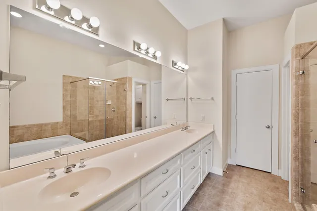 a spacious bathroom with a tub shower a sink and mirror