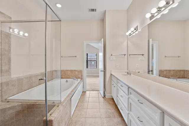 a spacious bathroom with a double vanity sink mirror and shower