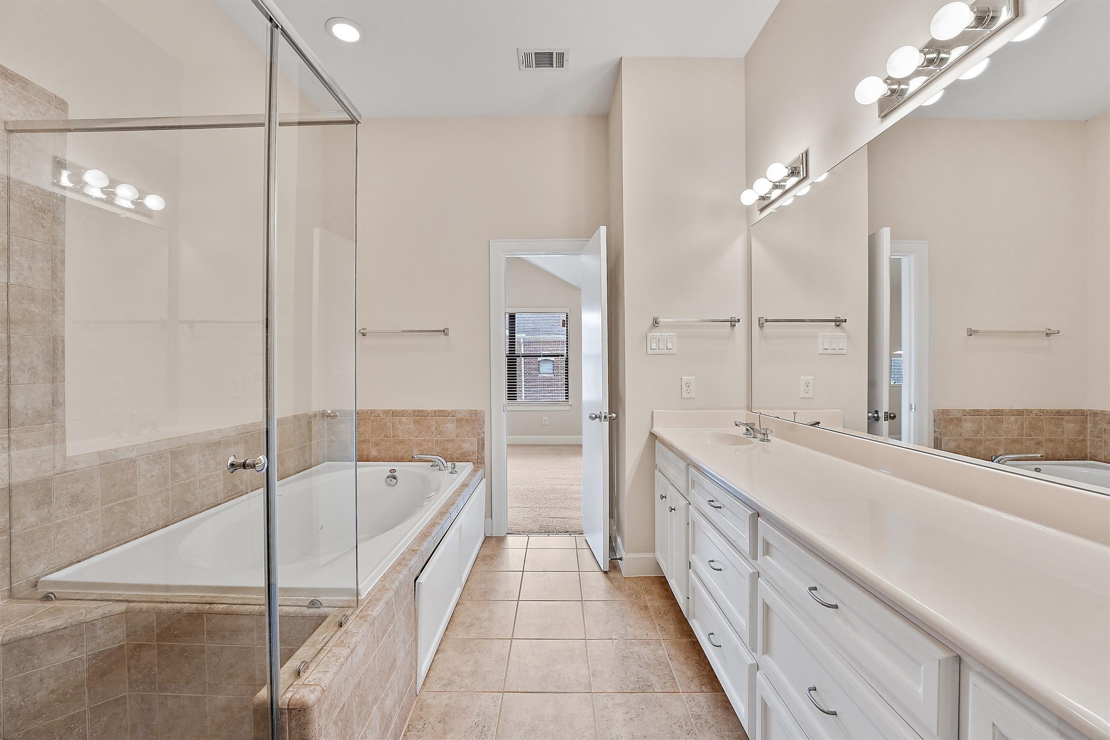 2710 Hullsmith Drive, Unit 903 Houston, TX 77063 - Photo 23 of 26 a spacious bathroom with a tub shower a sink and mirror