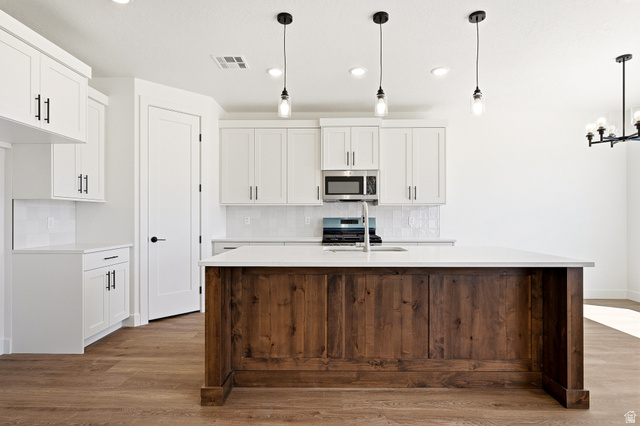 4978 North 75 East Enoch, UT 84721 - Photo 8 of 60 Kitchen featuring a kitchen island with sink, white cabinets, and decorative backsplash