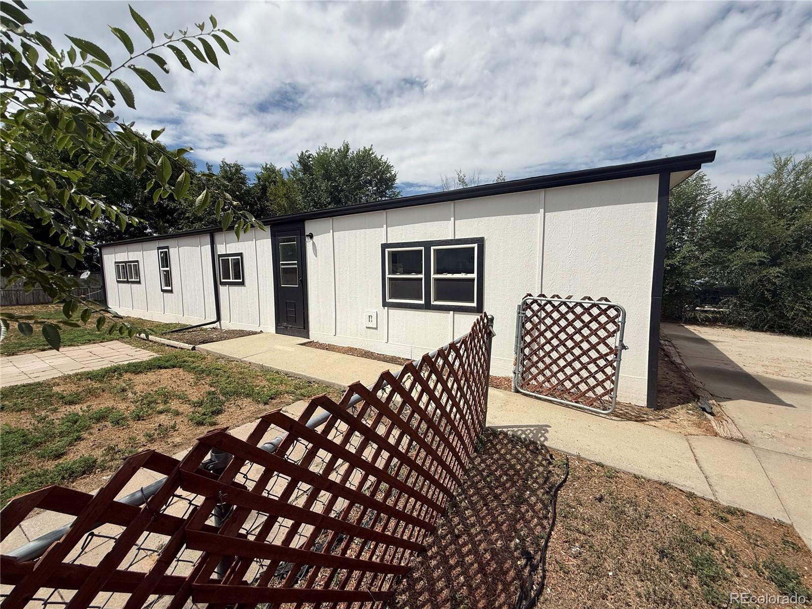 1045 Mac Davidson Circle Dacono, CO 80514 - Photo 11 of 32 a backyard of a house with wooden floor and fence