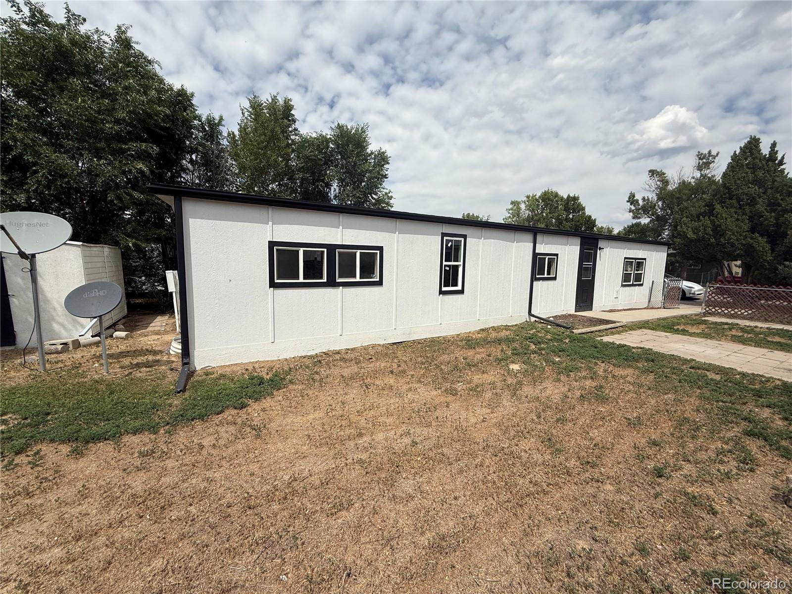 1045 Mac Davidson Circle Dacono, CO 80514 - Photo 13 of 32 a backyard of a house with table and chairs