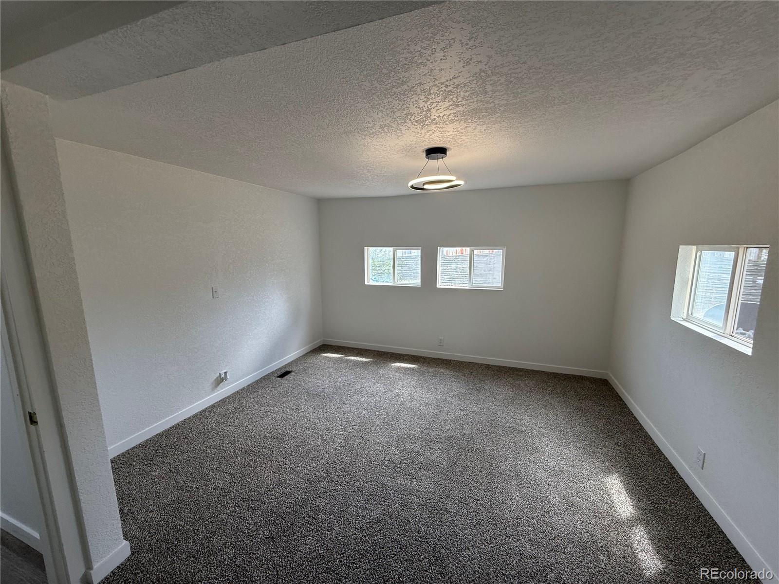 1045 Mac Davidson Circle Dacono, CO 80514 - Photo 17 of 32 an empty room with windows and ceiling fan view